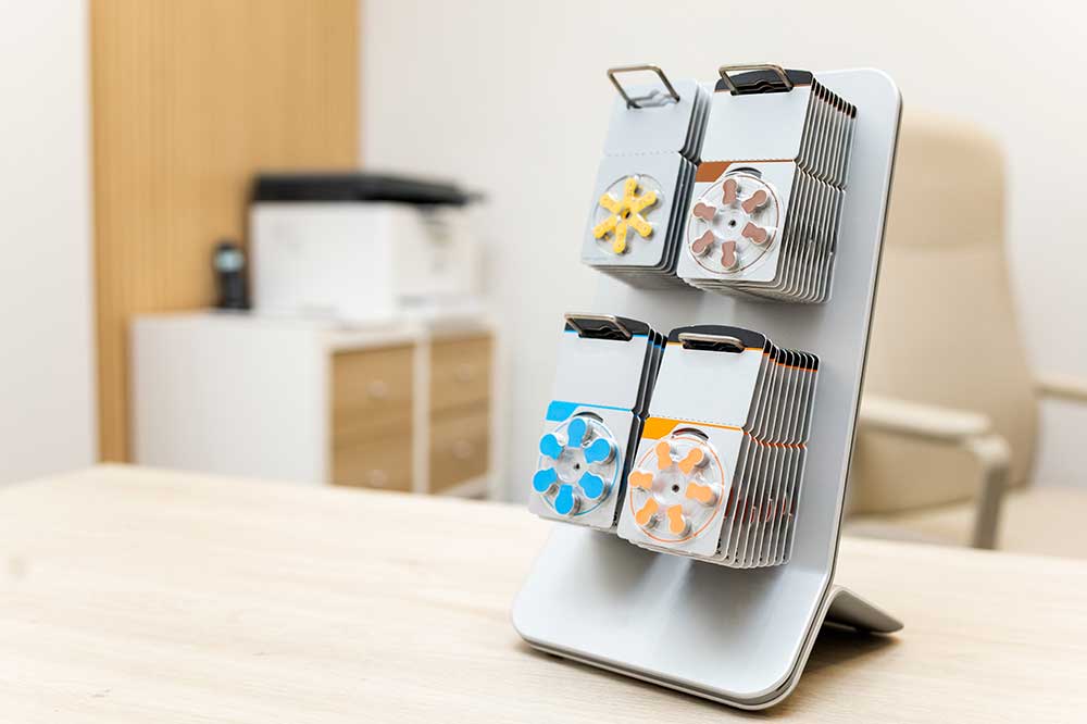 Display of color-coded hearing aid battery packs on a desk, for battery life tips from Staverman Hearing Centers in Jacksonville, FL